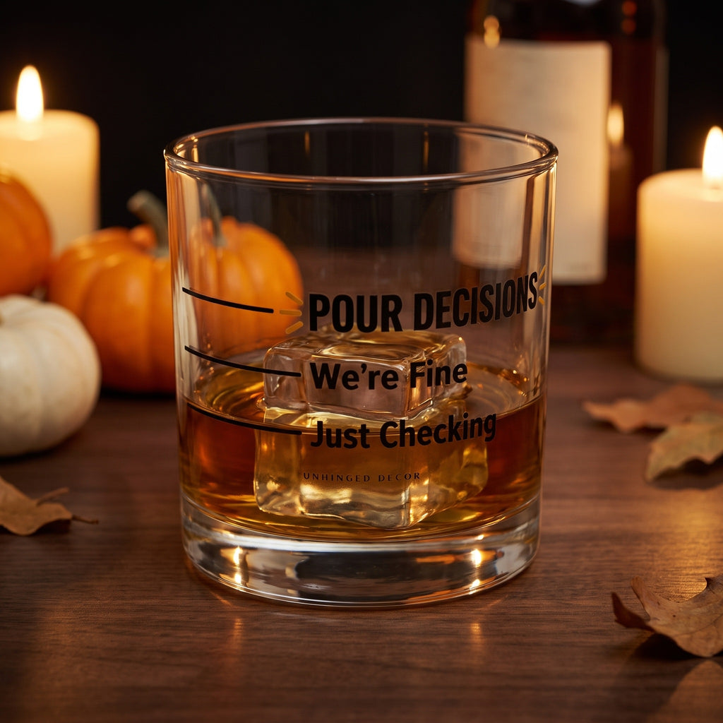 Pour Decision rocks glass 'Just Checking / We’re Fine' with whiskey on a big ice cube on a fall home bar with candles and pumpkins, Unhinged Decor